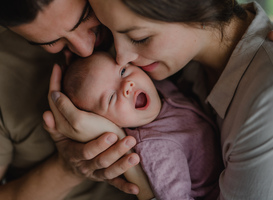 Normal_close-up-of-young-parents-holding-and-kissing-thei-2022-01-18-23-51-00-utc