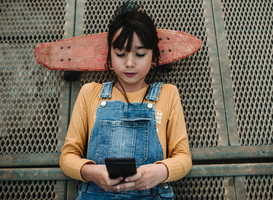 Normal_girl-with-smartphone-and-skateboard-lying-on-walkw-2022-03-04-05-49-25-utc