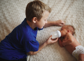 Normal_boy-feeding-newborn-baby-with-bottle-of-milk-2022-02-02-03-48-28-utc