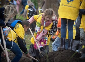 Minister van der Wal plant samen met kinderen boom tijdens Boomfeestdag