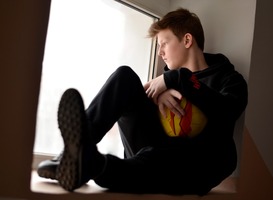 Normal_teenager-with-a-ball-sits-near-the-window-2023-11-27-05-00-58-utc__1_