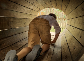 Normal_cute-boy-crawling-through-wooden-tube-or-tunnel-at-2023-11-27-05-30-26-utc