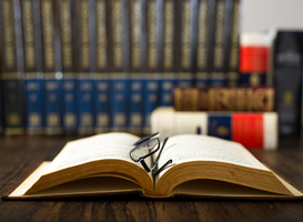 Normal_open-book-and-glasses-on-a-wooden-table-and-books-2024-01-24-20-45-54-utc