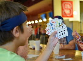 Normal_child-playing-cards-with-his-family-at-a-restauran-2023-11-27-05-20-37-utc