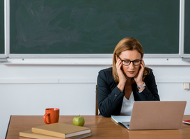 Normal_female-teacher-sitting-at-computer-desk-and-having-2023-11-27-05-00-27-utc