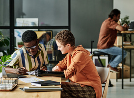 Normal_two-young-intercultural-interns-discussing-notes-i-2023-11-27-05-31-47-utc