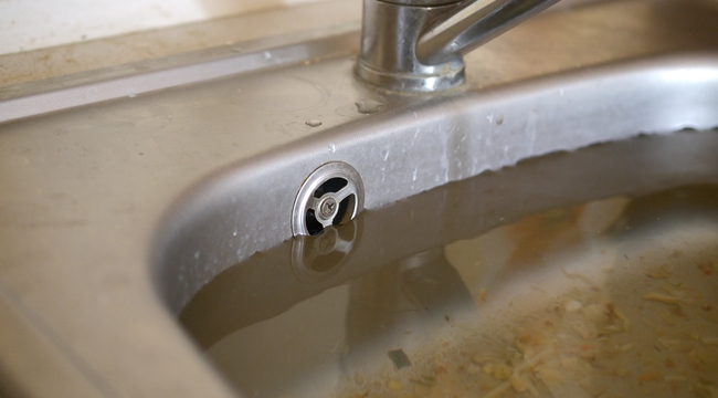Carousel_stainless-steel-sink-plug-hole-close-up-full-of-wa-2025-03-17-07-29-58-utc
