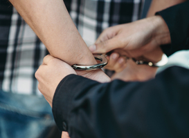 Normal_police-officer-puts-handcuffs-on-a-car-thief-2024-12-05-04-38-44-utc